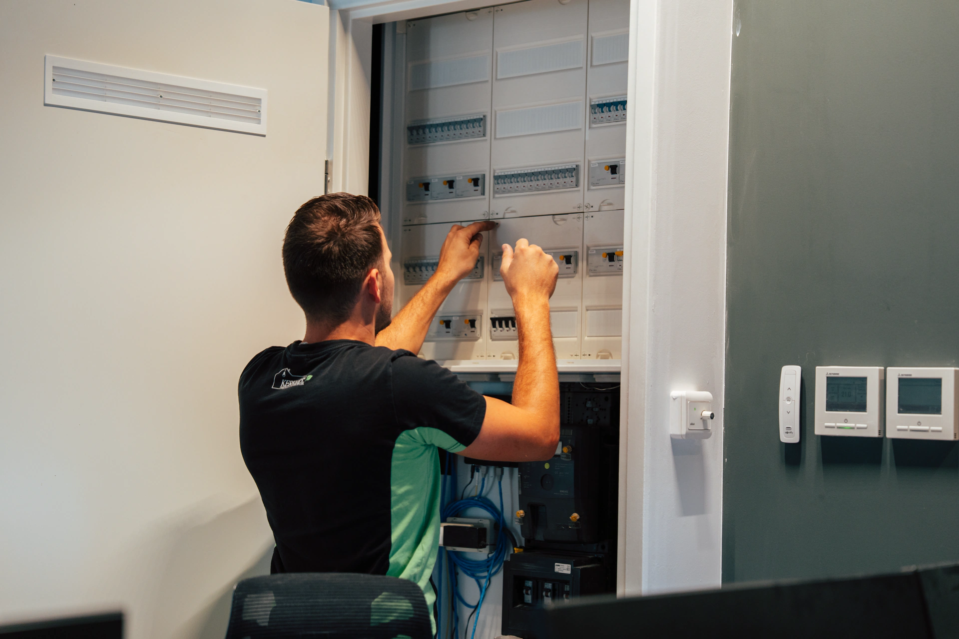 Elektriciën van Kerkhoff aan het werk bij de meterkast in een hal